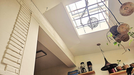 FirTec+® 1300T infraroodpaneel aan verstelbare hangkabels gemonteerd in keuken met lichtkoepel en houten dakbalk