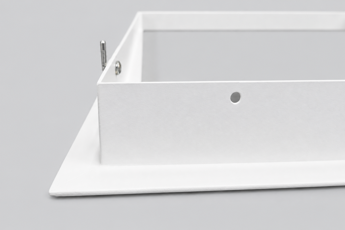 Detail van de witte bovenrand van het inbouwframe met zichtbaar bevestigingsgat