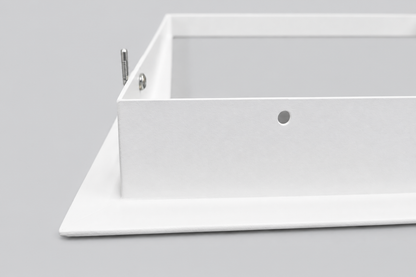 Detail van de witte bovenrand van het inbouwframe met zichtbaar bevestigingsgat